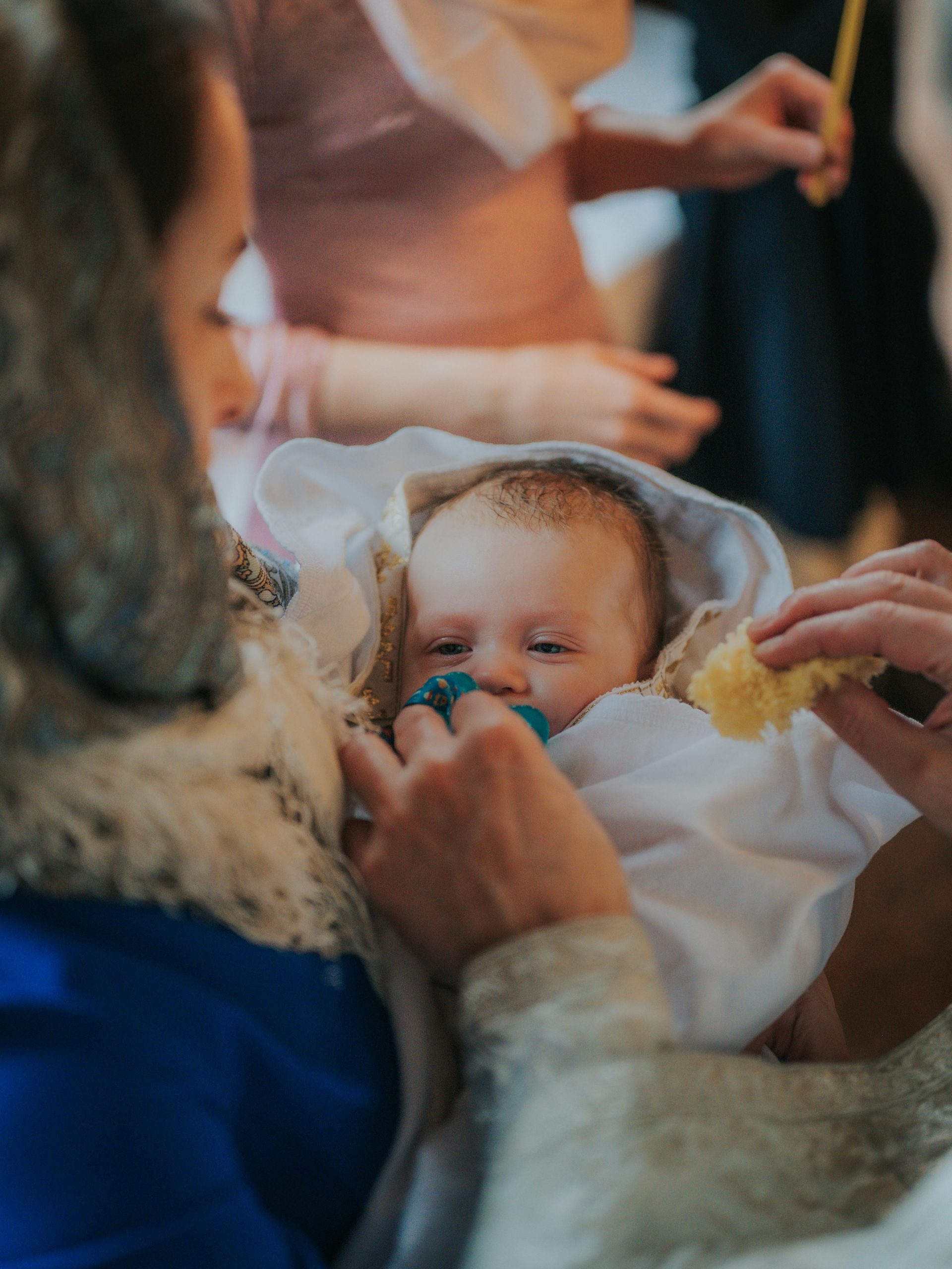 A touching scene from a baptism ceremony showing familial bonding and care.